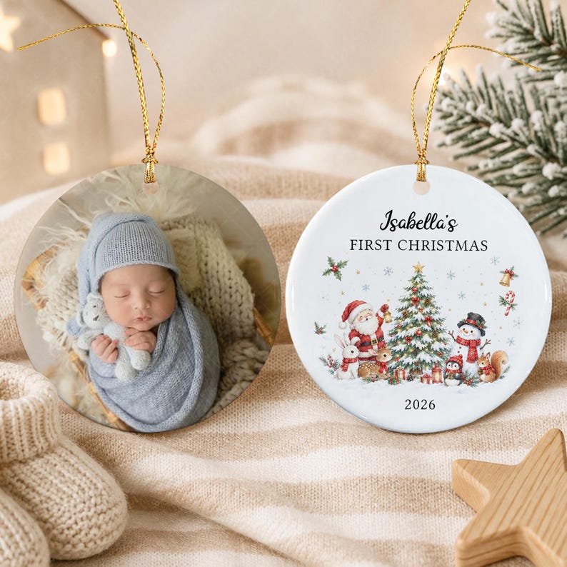 Two round ceramic ornaments with gold hanging strings. One ornament features a photograph of a baby wrapped in a blue blanket holding a toy.