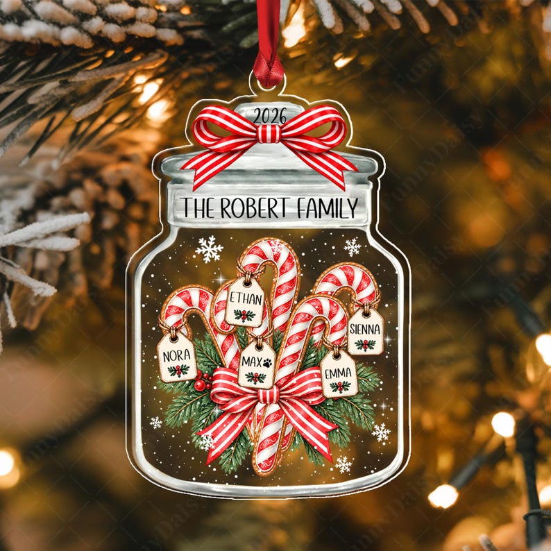 A clear jar-shaped Christmas ornament featuring a red ribbon at the top with the year 2026.