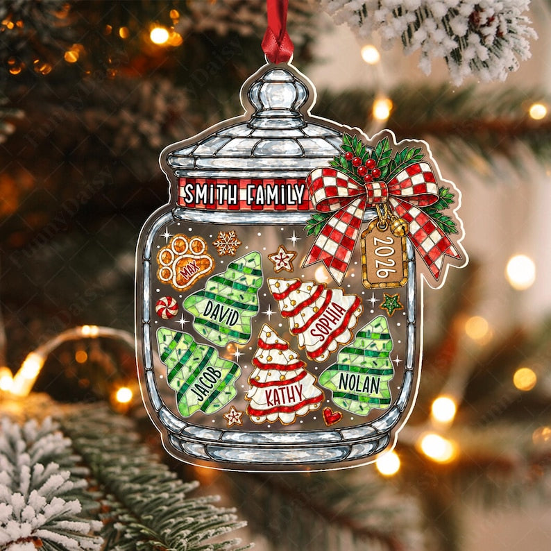 A clear glass jar ornament featuring a red and white checkered ribbon, a tag labeled 2026, and the text Smith Family. Inside are decorative cookies shaped like Christmas trees and a paw print, each personalized with names.