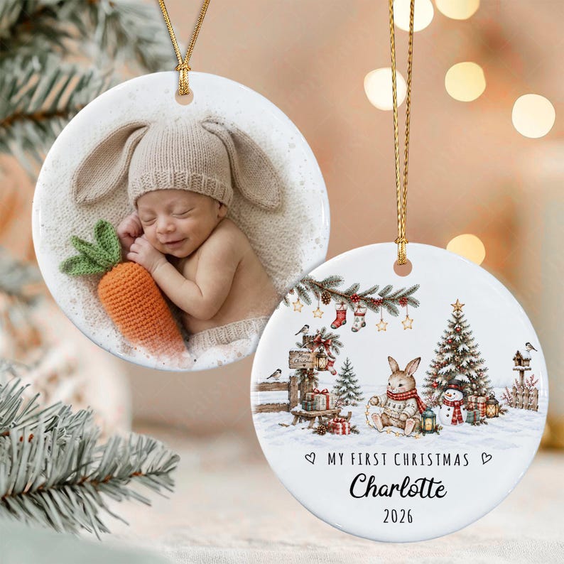 Two round white ceramic ornaments with gold hanging strings. One features a photograph of a baby wearing a tan bunny-ear hat holding a crocheted orange carrot.
