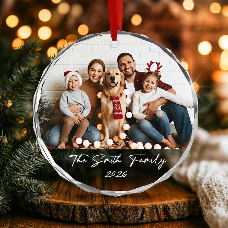 A circular clear acrylic ornament featuring a printed family photograph of two adults, two children, and a golden retriever wearing a red scarf.