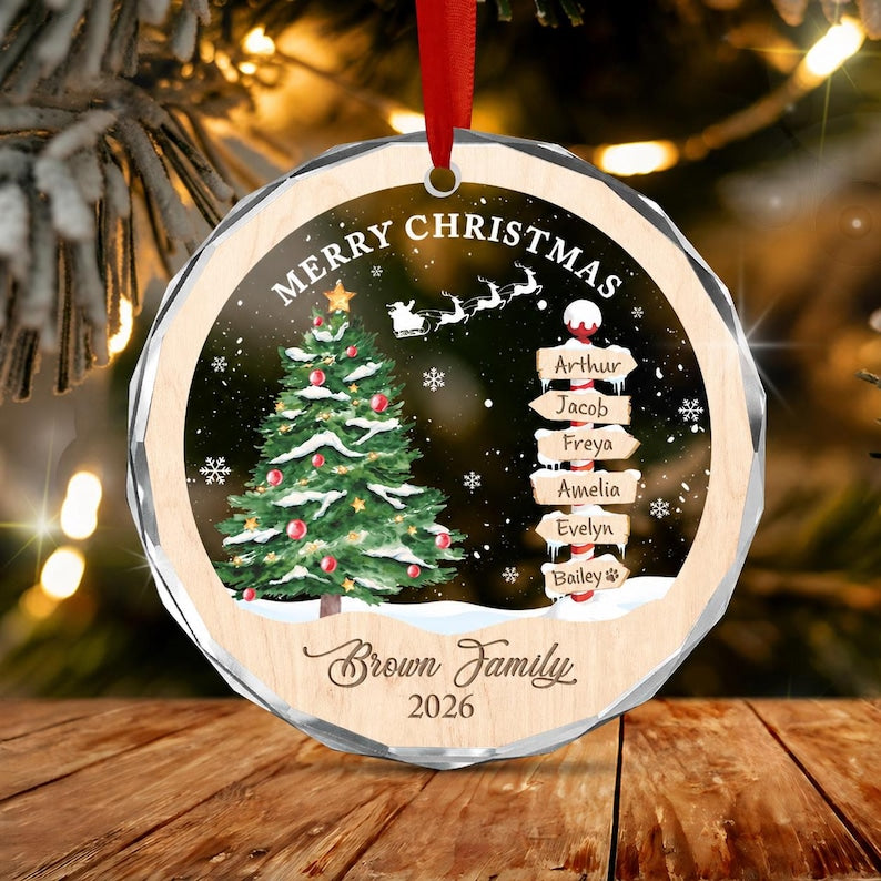 A round, faceted Christmas ornament with a red ribbon, featuring a green Christmas tree, a signpost with the names Arthur, Jacob, Freya, Amelia, Evelyn, and Bailey, the text Merry Christmas, Brown Family, and the year 2026.