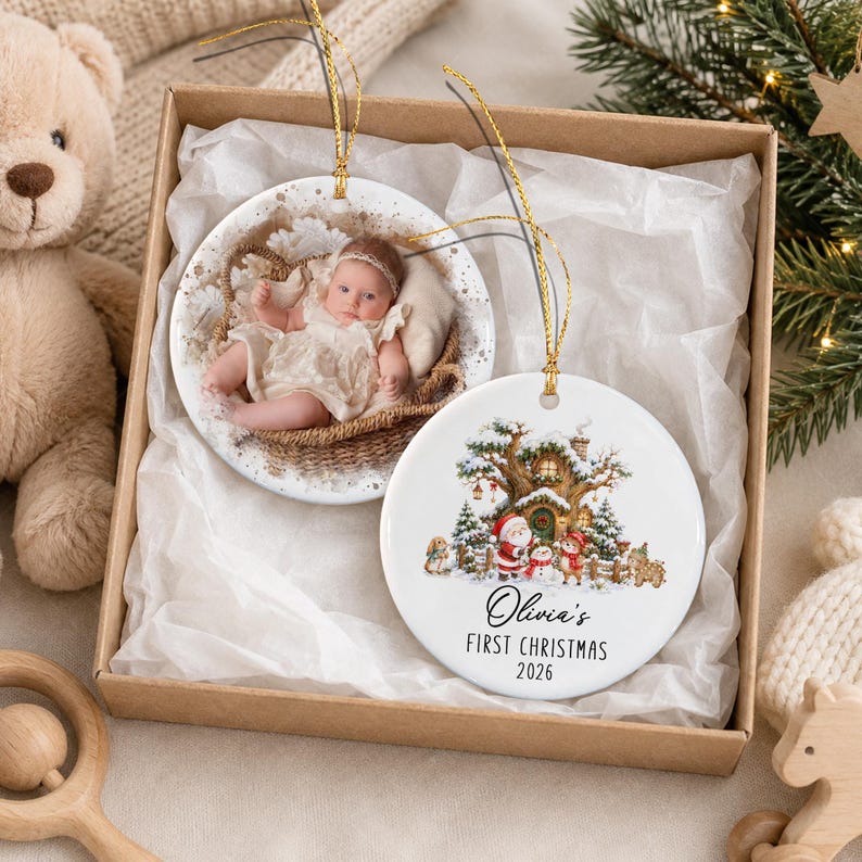 Two round ceramic ornaments with gold hanging strings. One ornament features a photograph of a baby in a basket.