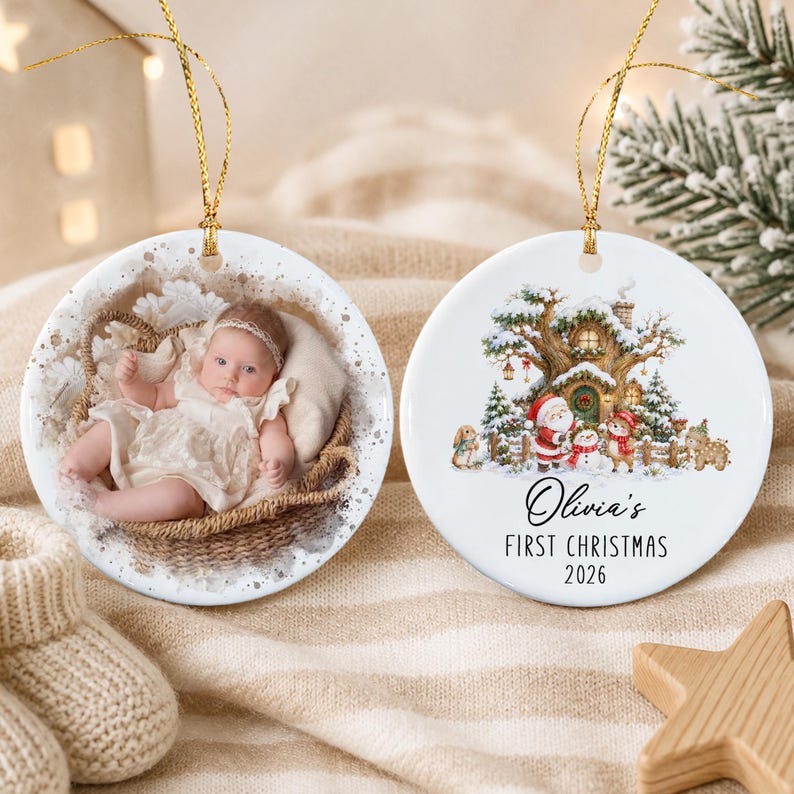 Two round white ceramic ornaments with gold hanging strings. One ornament features a photograph of a baby in a white dress inside a woven basket.