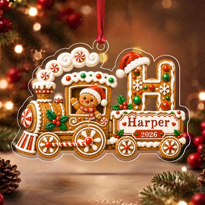 A gingerbread train Christmas ornament featuring a gingerbread person in the engine, a large letter H with a Santa hat, and a banner displaying the name Harper and the year 2026.