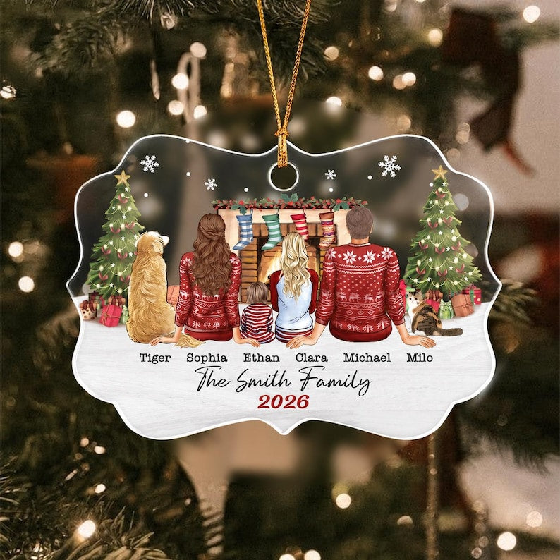 A custom Christmas ornament featuring a family of four and two pets sitting before a fireplace.
