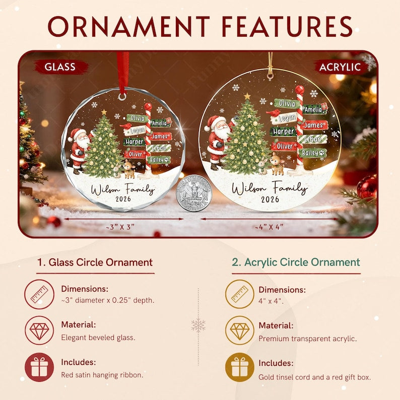 Two circular Christmas ornaments, one glass and one acrylic, featuring a Santa Claus, a decorated tree, and a signpost with names. The text reads Wilson Family 2026. A US quarter coin is placed between them for scale.