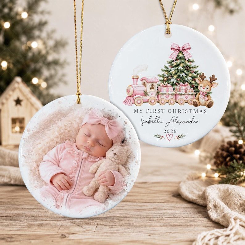 Two round white ceramic ornaments with gold hanging strings. One features a photograph of a baby in pink clothing holding a teddy bear.