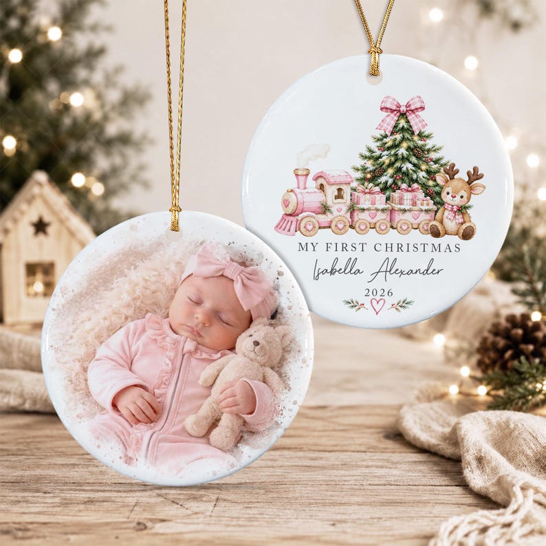 Two round white ceramic ornaments with gold hanging strings. One features a photograph of a baby in pink clothing holding a teddy bear.
