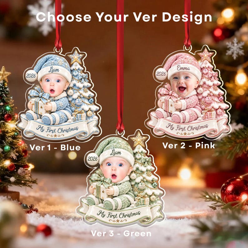 Three hanging Christmas ornaments featuring a baby in a hat holding a gift next to a decorated tree. Each ornament displays the text 'My First Christmas', '2026', and a name.