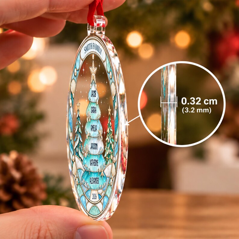 An oval-shaped clear acrylic Christmas ornament featuring a printed design of a stylized blue and white Christmas tree with the text "SMITH FAMILY" and names "JACOB, SARAH, AMELIA, JACKSON, KATHERINE, ALEXANDER" and "2026".