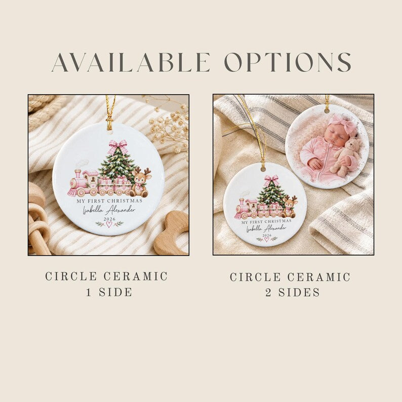 Two white circular ceramic ornaments with gold hanging strings. One shows a pink train, Christmas tree, and reindeer with text My First Christmas Isabella Alexander 2026. The other shows the same design plus a photo of a baby.